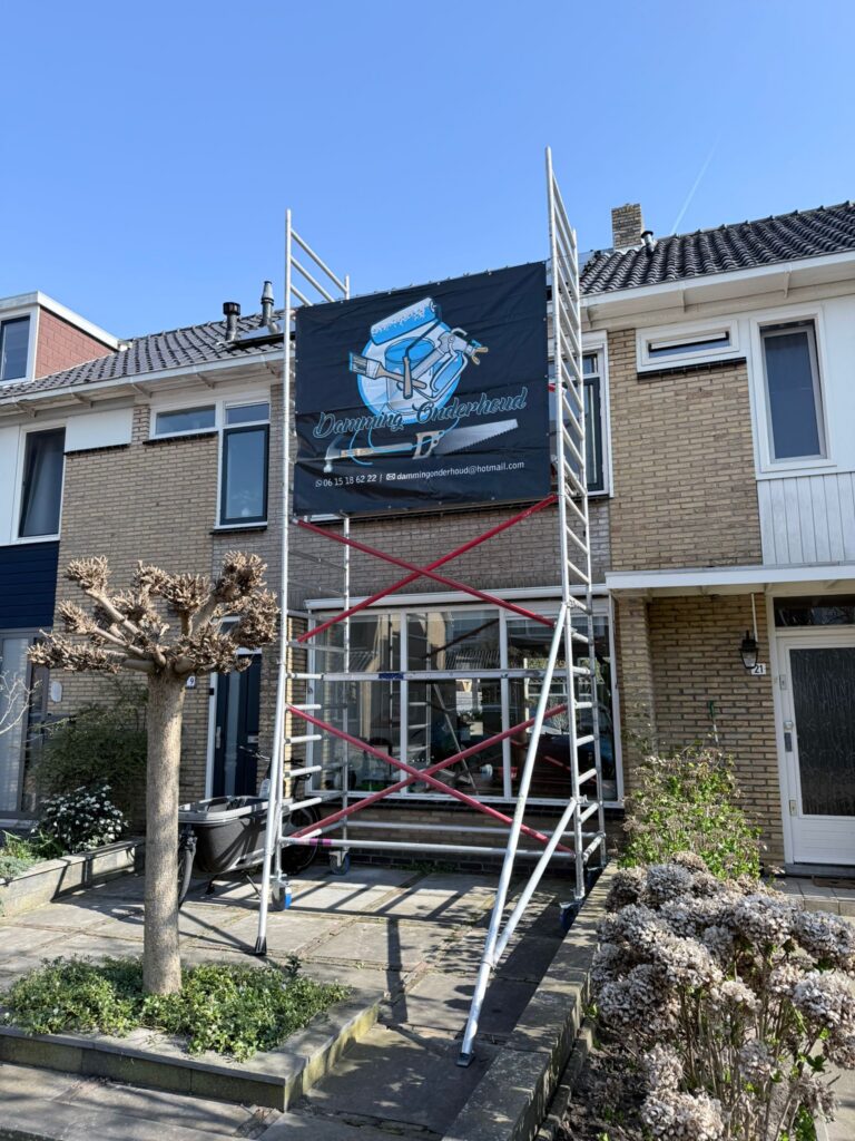 Steiger bij woning met Damming Onderhoud spandoek.
