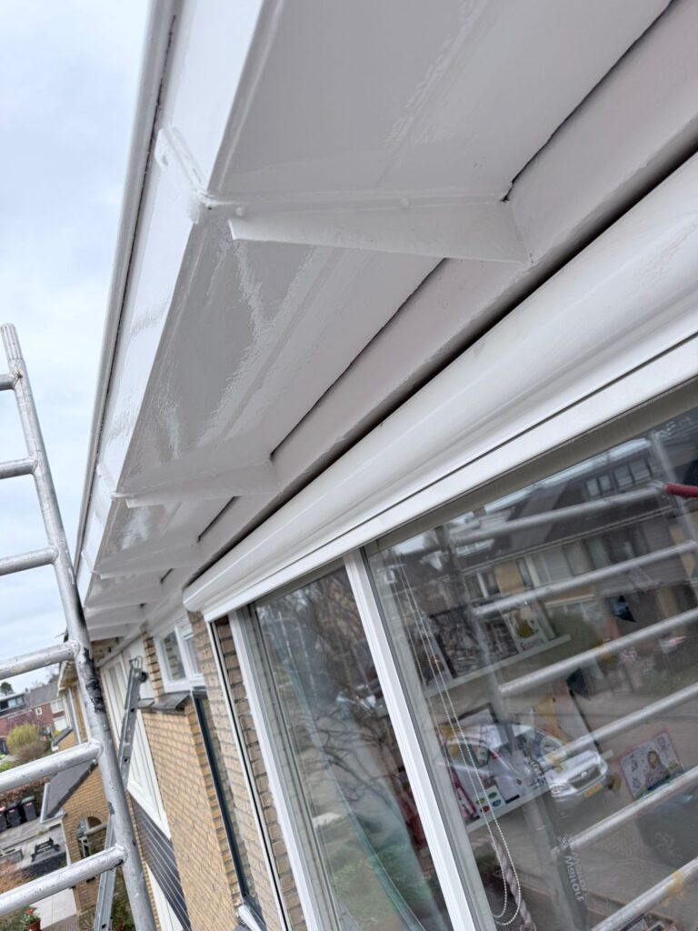 Geverfd huis met ladder tegen de gevel.