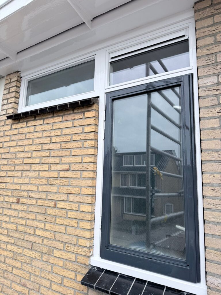 Buitenmuur met modern grijs en wit kozijn