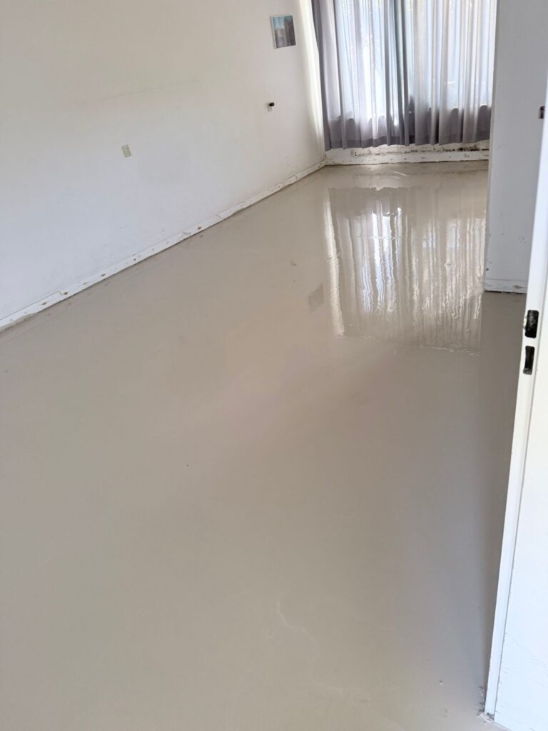 Leeg huis met natte vloer en gordijnen.