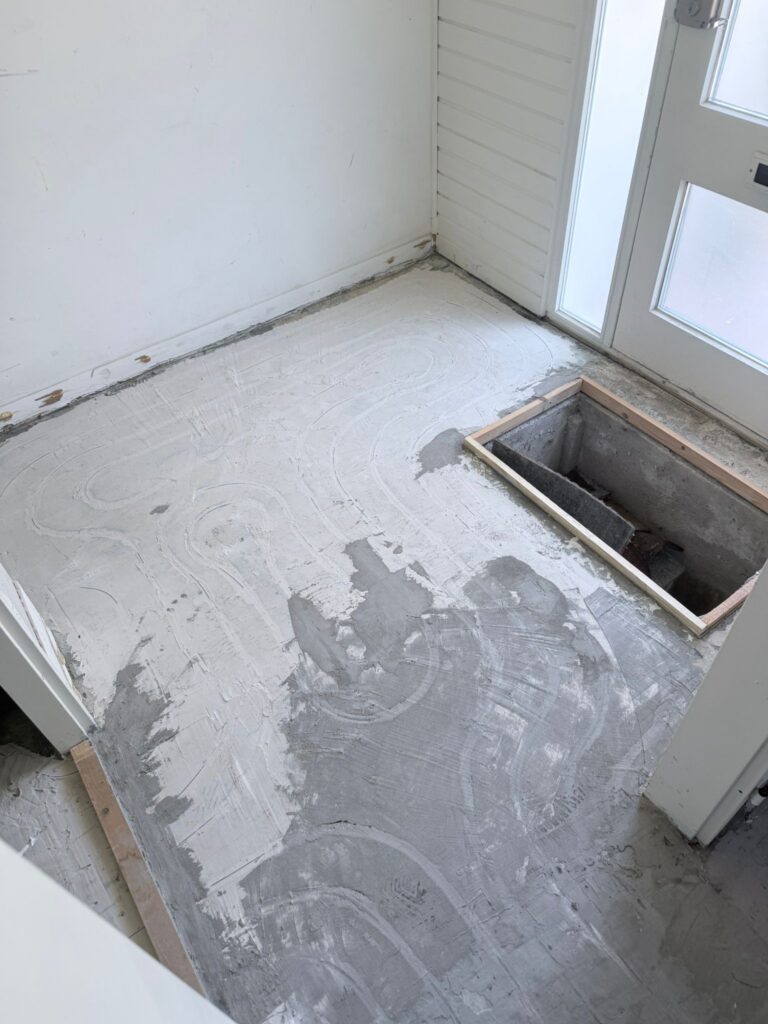 Vloer met pleisterwerk in renovatie, zonder vloerbedekking.