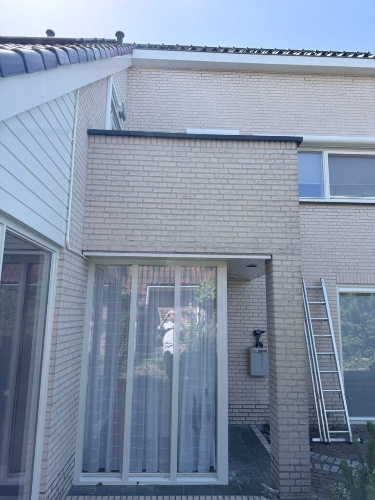 Wit geschilderde kozijnen en voordeur na buitenschilderwerk en houtrotreparatie aan een woning in Egmond-Binnen