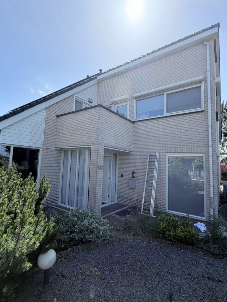 Wit geschilderde kozijnen en voordeur na buitenschilderwerk en houtrotreparatie aan een woning in Egmond-Binnen