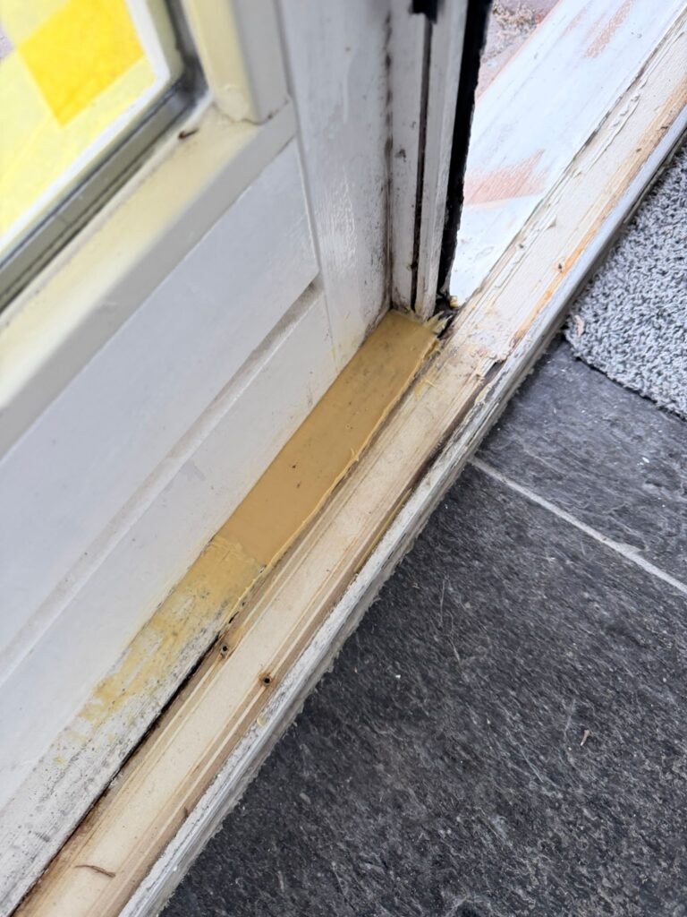 Wit geschilderde kozijnen en voordeur na buitenschilderwerk en houtrotreparatie aan een woning in Egmond-Binnen