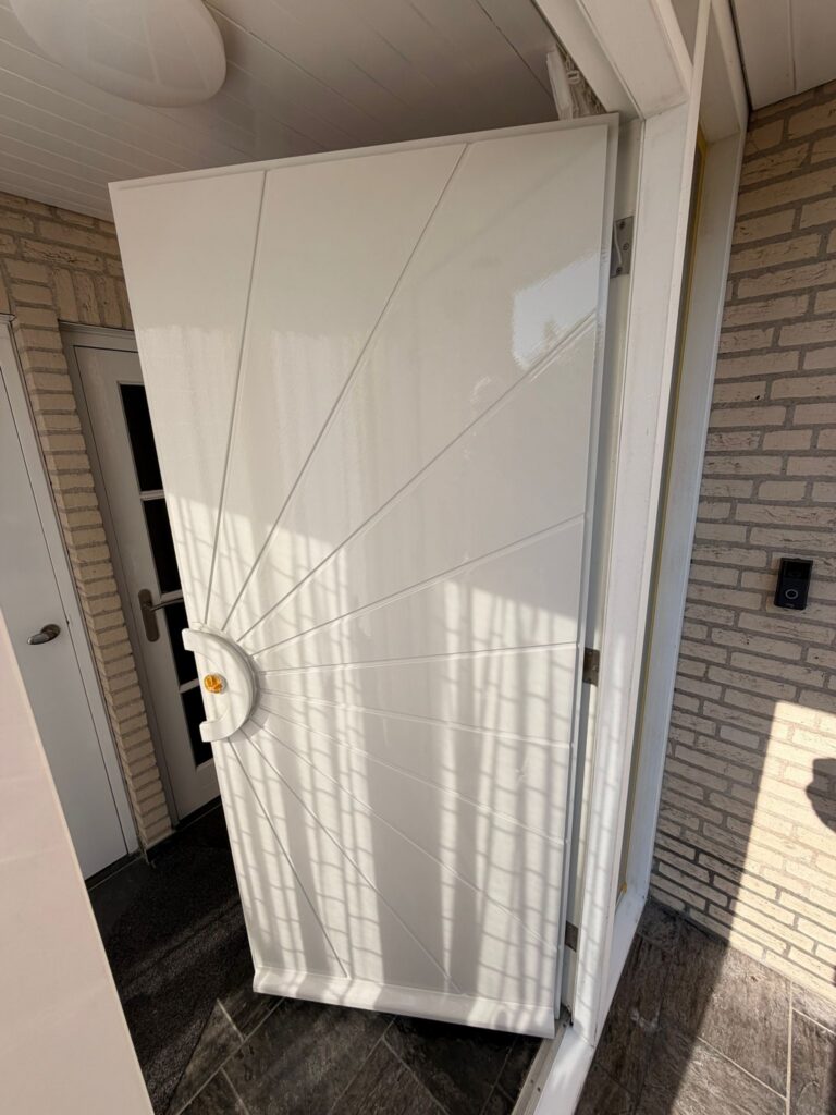 Wit geschilderde kozijnen en voordeur na buitenschilderwerk en houtrotreparatie aan een woning in Egmond-Binnen