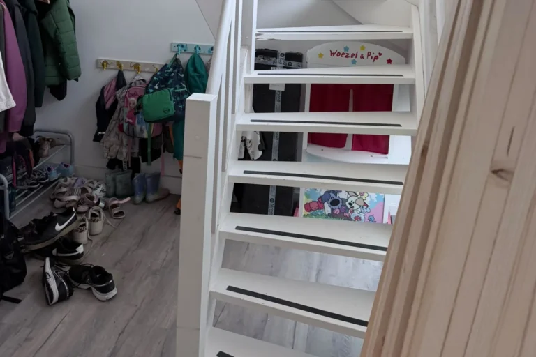 Open trap met donkere strips en slijtplekken op de treden, voor het schilderwerk door Damming Onderhoud