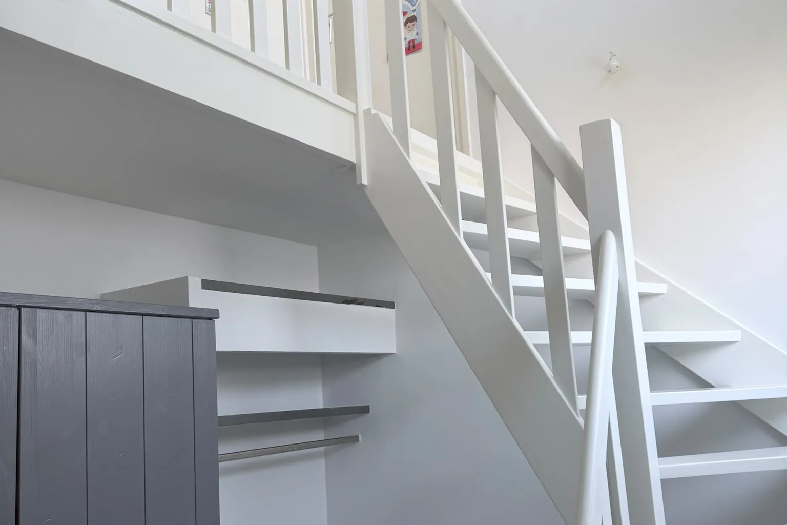 Trappenhuis met gestucte wanden en trap met balustrade in RAL 9010 zijdeglans door Damming Onderhoud
