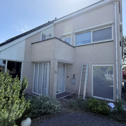 Woning van lichte baksteen met een ladder tegen de voorgevel in Castricum